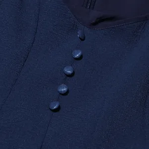 Vista dettagliata dei bottoni rivestiti in tessuto sull'abito blu navy in stile francese