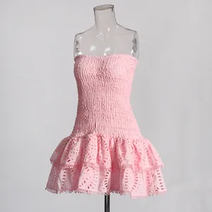 Detail van een roze strapless mini-jurk met gesmokte body en geborduurde ruches