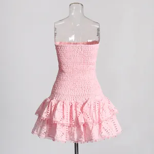 Detailweergave van roze strapless jurk met smokwerk en geborduurde ruchesrok