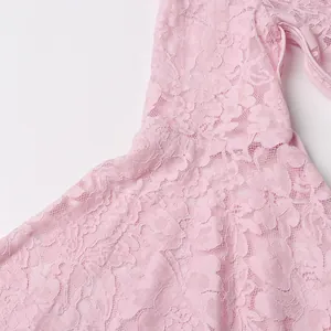 Close-up detail of soft pink floral lace fabric used for long bell sleeve dress stitching