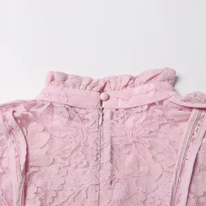 Detail shot of a pink lace dress featuring a stand collar with elegant ruffled edges