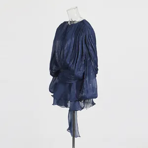 Detailed side view of navy blue pleated dress with puff sleeves and ruffle hem texture.