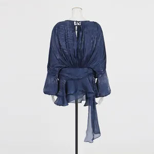 Back view of a navy blue pleated mini dress with puff sleeves and ruffled hem details