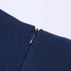 Dettaglio ravvicinato della cerniera invisibile su un abito in chiffon blu scuro testurizzato