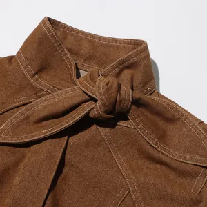 Dettaglio del colletto di una giacca retrò marrone con elegante nodo e cuciture bianche