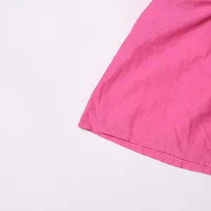 Detailopname van de roze jurkzoom met fijne stiksels en hoogwaardige stoftextuur