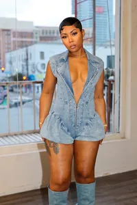 Detail view of a sexy acid wash denim romper with a deep V-neck and front zipper closure.