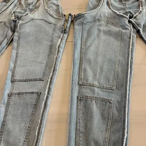 Gros plan sur la coupe irrégulière et les bords effilochés de ce jean extensible.