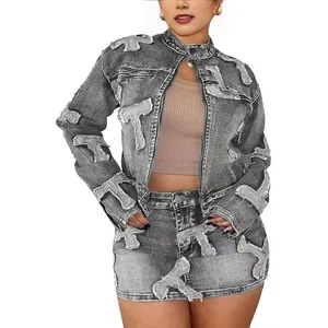 Detail of grey acid wash denim set featuring unique T-patch embroidery on jacket and skirt