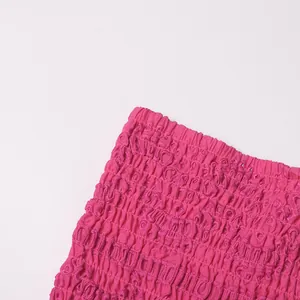 Detailopname van fuchsia gesmokte stof met fijn borduursel op een stijlvolle rok
