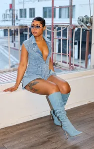 Detailed view of light blue denim sleeveless romper with zipper front on a fashion model