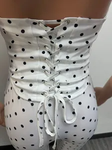 Vue rapprochée d'une combinaison blanche à pois avec détail de laçage style corset au dos