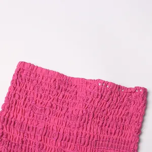 Close-up van het roze gesmokte stofdetail van een sexy geborduurde jurk in EU-stijl