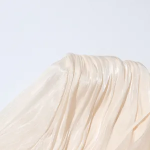 Macro view of elegant cream white pleated dress fabric with shimmering satin-like texture