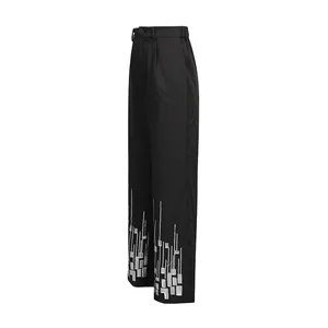 Macro view of heavy industry silver geometric embroidery on black straight-leg trousers