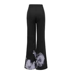Back view of black high-waisted flare trousers with elegant lavender floral print details