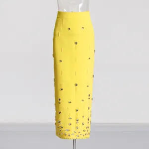 Detailed view of yellow high-waisted pencil skirt with elegant rhinestone beading