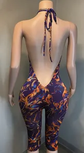 Back view of a halter neck backless jumpsuit with vibrant abstract print and slim fit
