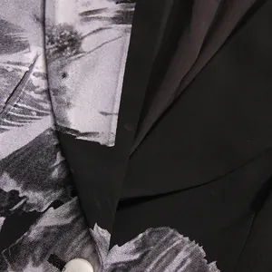 Close-up detail of stylish black and grey floral print on blazer lapel and fabric texture.