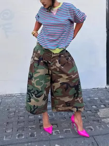 Street style women's camo wide-leg pants with striped t-shirt and pink heels.