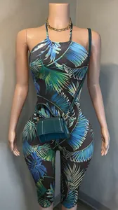 Detail of a tropical palm leaf print halter backless slim-fit stretchy jumpsuit.