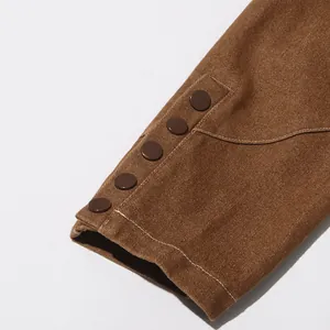 Dettaglio ravvicinato in twill marrone con cinque bottoni decorativi in stile vintage