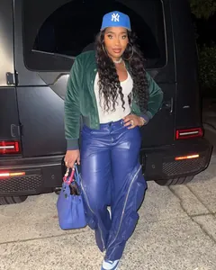 Detailed view of blue wide-leg faux leather pants with large decorative zippers and cargo pockets