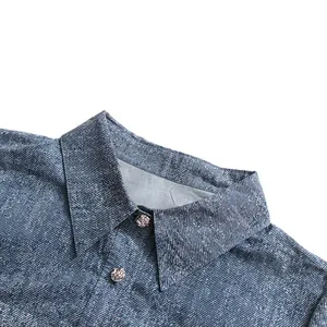 Close-up van de kraag van een blauw denim overhemd met textuurstof en metalen knopen
