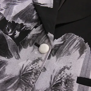 Detailed close-up showing the floral print fabric texture and white button of the casual blazer