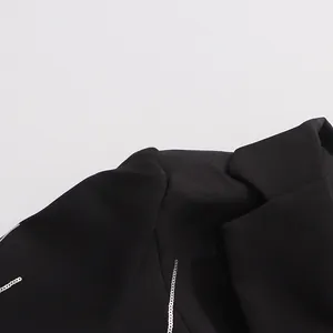 Detailed view of black blazer shoulder with silver sequin lines for high-end finish.