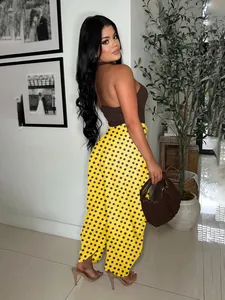 Detailed view of yellow polka dot wide-leg trousers styled with a brown halter top
