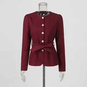 Detailed view of a French retro palace style burgundy top with pearl buttons and bow tie.