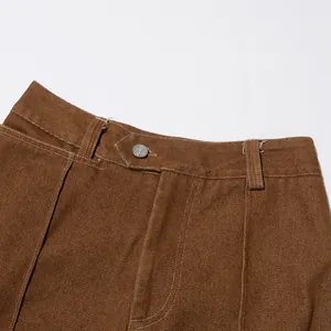 Dettaglio del bottone e delle cuciture bianche su pantaloni vintage marroni