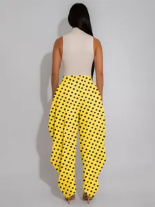 Back view of vibrant yellow polka dot wide-leg tulip pants with unique draped hem design