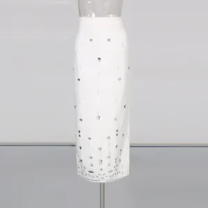 Detail of elegant white high-waisted pencil skirt with sparkling rhinestone and beadwork
