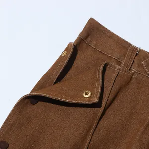 Primo piano dei pantaloni vintage marroni che mostra la tasca e il bottone a pressione dorato