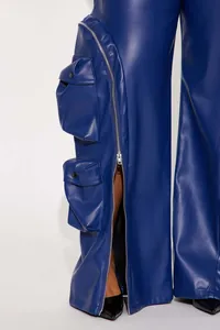 Detailed view of blue faux leather cargo pants with silver zipper and flap pockets.