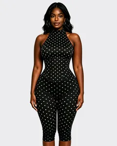 Vue détaillée de face d'une combinaison dos nu noire à pois blancs et taille corset