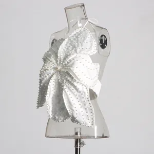 Detailed side view of white flower-shaped halter top with heavy pearl beading.