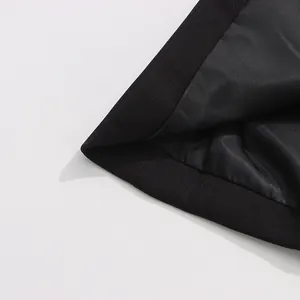 Close-up detail of the black blazer lining and hem finish showing quality stitching.