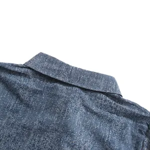 Detailopname van de elegante reverskraag op een blauw getextureerd denim overhemd
