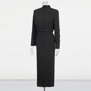 Elegant black two-piece set featuring a beaded cropped top and high-waist maxi skirt.
