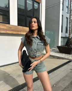 Full body view of a model wearing a trendy denim two-piece set in an urban environment