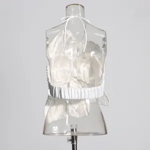 Back view detail of white beaded halter top featuring elastic band on clear mannequin.