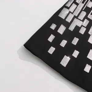 Close-up detail of shimmering silver sequin geometric patterns on black blazer fabric