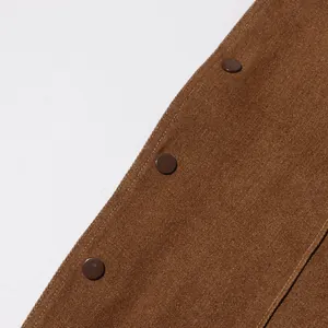 Primo piano del tessuto denim marrone e dei bottoni su giacca vintage da donna