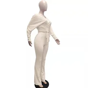 Vista laterale di un set beige in maglia a coste con top annodato e pantaloni