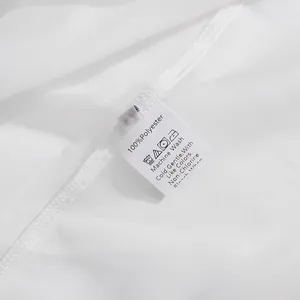 Gedetailleerde opname van het 100% polyester waslabel op een wit kledingstuk detail