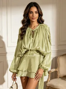 Elegant sage green pleated puff sleeve mini dress with tie neck and ruffle hem details