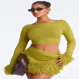 Detail view of stylish olive green knitted long-sleeve top and fringed skirt set